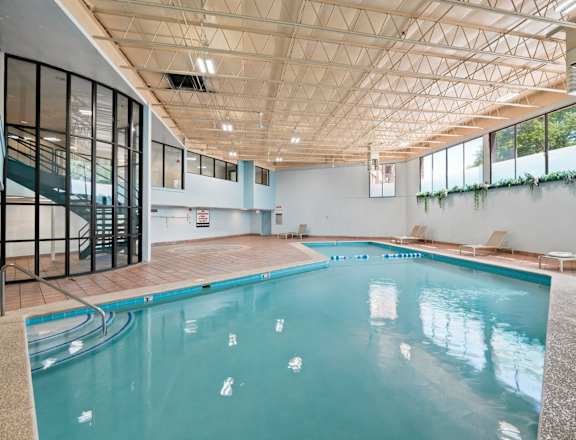 A large indoor swimming pool with a glass wall on one side.