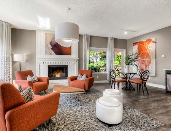 A living room with a fireplace and a painting on the wall.
