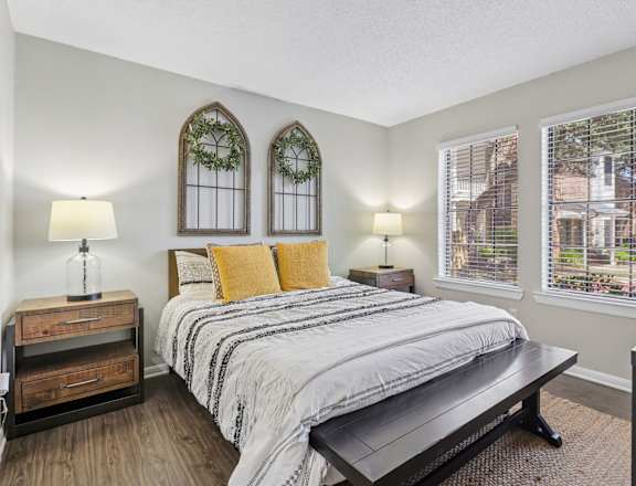 A bedroom with a bed, nightstand, and window.