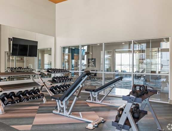 a spacious fitness center with cardio machines and weights