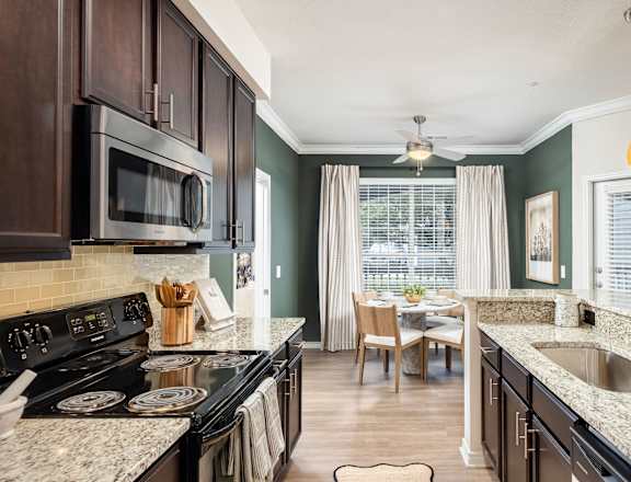 A kitchen with a black stove top oven and a black microwave.