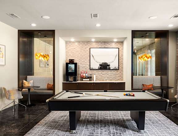 A pool table is in the middle of a room with a television and a couch.