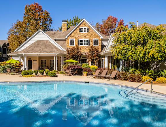 A house with a pool in front of it.