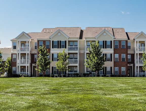 an image of an apartment building on a green lawn at Brickshire Apartments, Merrillville