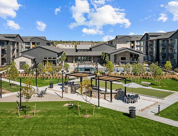 an outdoor area with picnic tables in front of an apartment building