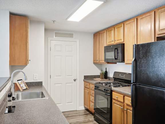 a kitchen with black appliances and wooden cabinets