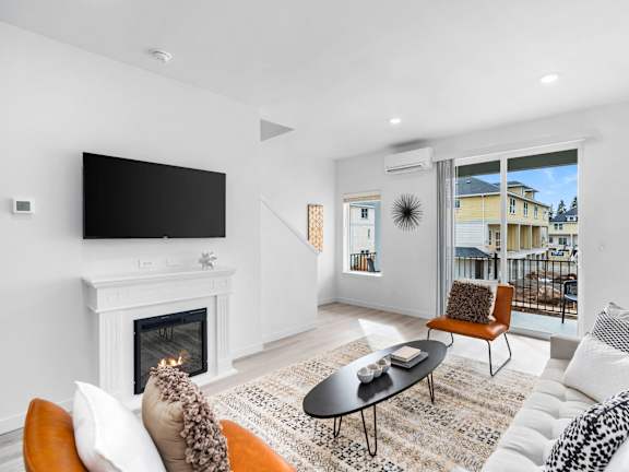A living room with a fireplace and a flat screen TV. at Holmes Park Townhomes, Oregon City, OR