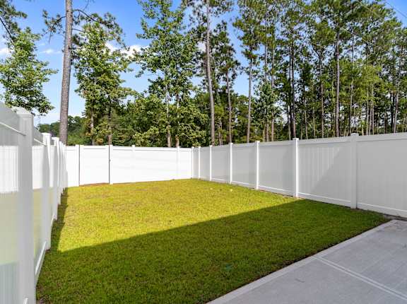 A white fence encloses a green yard.