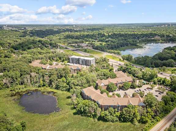 an aerial view of a campus with a lake and buildings