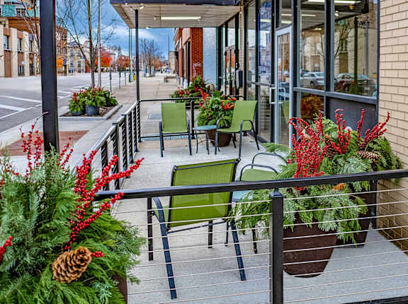 A balcony with a table and chairs surrounded by plants.