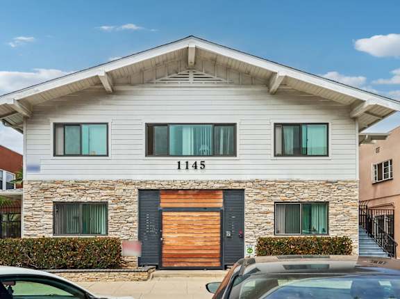 A modern house with a stone facade and a wooden door.