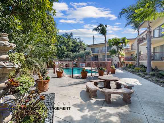 A patio area with a pool and a fountain.