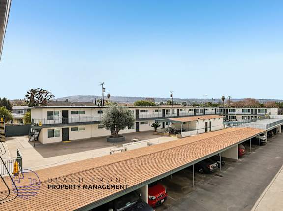A parking lot with a sign that says "Beach Front Property Management".