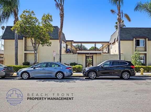 two cars parked in a parking lot in front of an apartment building