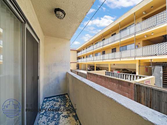 A balcony with a view of a building and a blue sky.