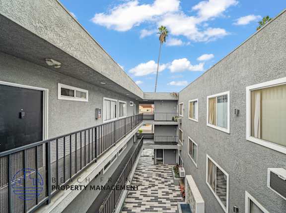 A balcony with a black railing and a tiled floor.