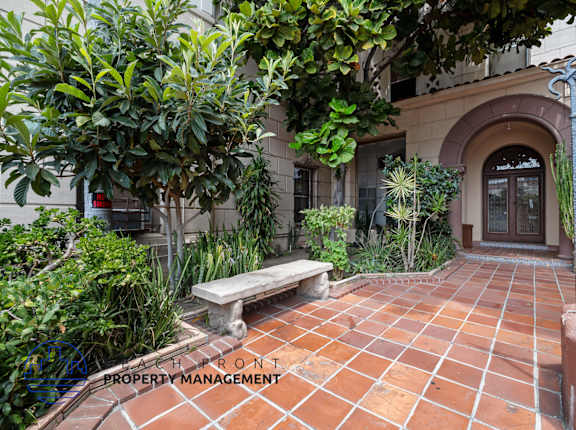 a courtyard with a bench and plants in front of a building