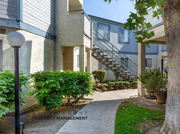 A tree is in front of a building with a staircase.