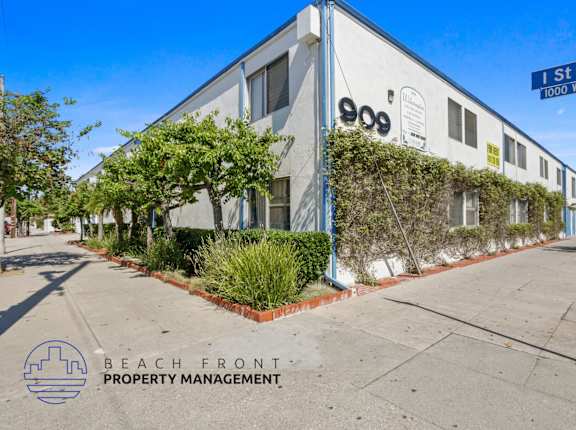 A building with the number 900 on it is shown with a sign that says 1st St 1000 W.