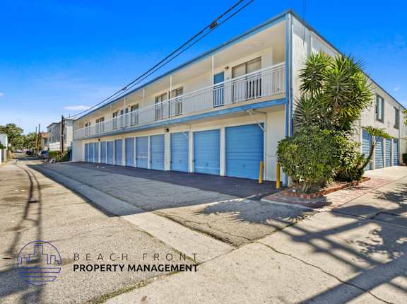 A building with a blue door is managed by Beach Front Property Management.