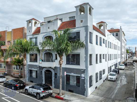 A street view of a building with cars parked in front.