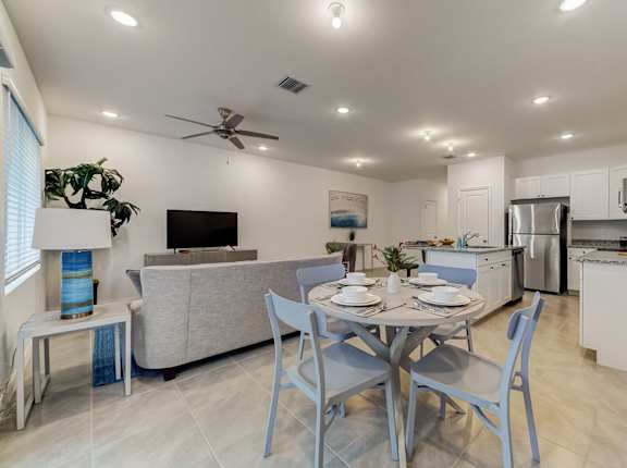 a dining area with a table and chairs and a living room with a kitchen