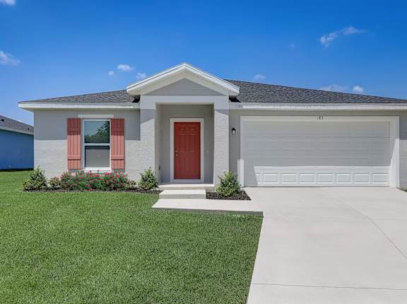 House with a grey roof, red door, large garage, driveway, and lawn.
