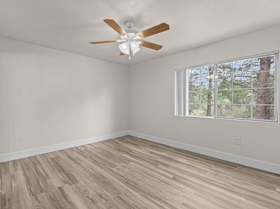 A room with a ceiling fan and a window.