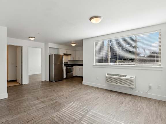 A kitchen with a refrigerator, microwave, and oven.