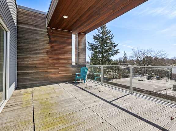 A wooden deck with a blue chair and a wooden house.