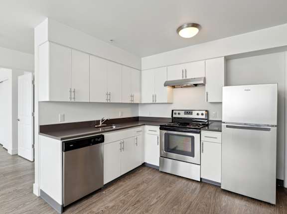 A modern kitchen with white cabinets and stainless steel appliances.