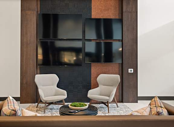 Two chairs are placed in front of a fireplace.