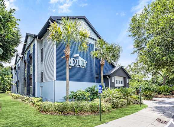 a blue building with palm trees in front of it