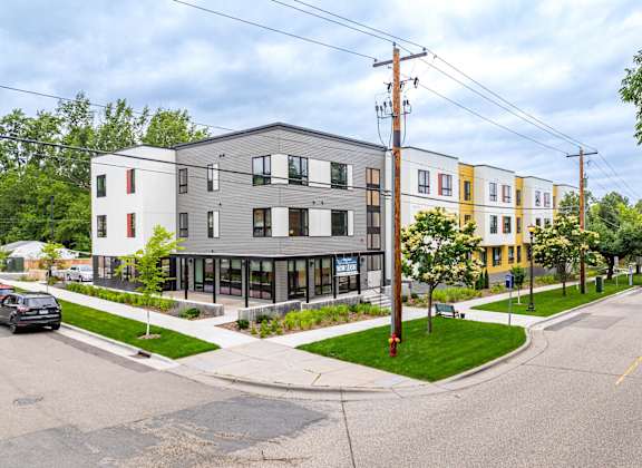 a street view of a row of apartment buildings on a street corner