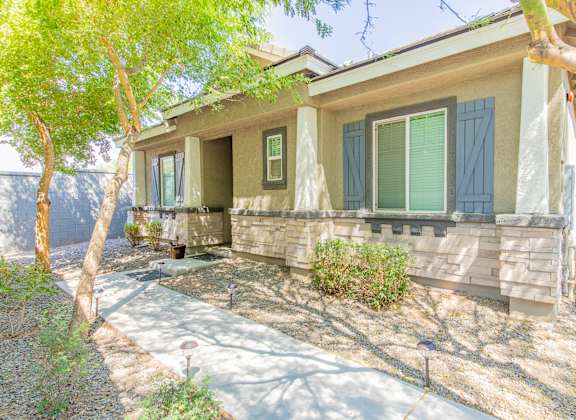 a house with green shutters and a sidewalk in front of it at Villas on Olive in Peoria, AZ 85345