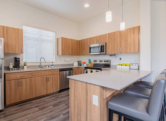 a kitchen with wooden cabinets and a white counter top at Villas on Olive in Peoria, AZ 85345