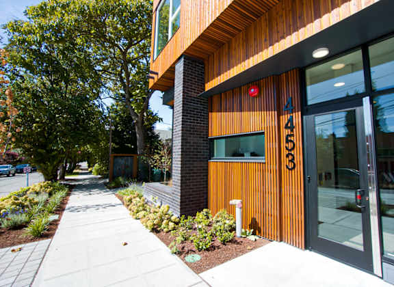 the outside of a building with a sidewalk and trees