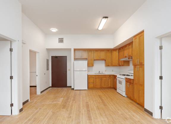 a large kitchen with white appliances and wooden cabinets