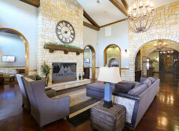 A living room with a stone wall and a large clock.