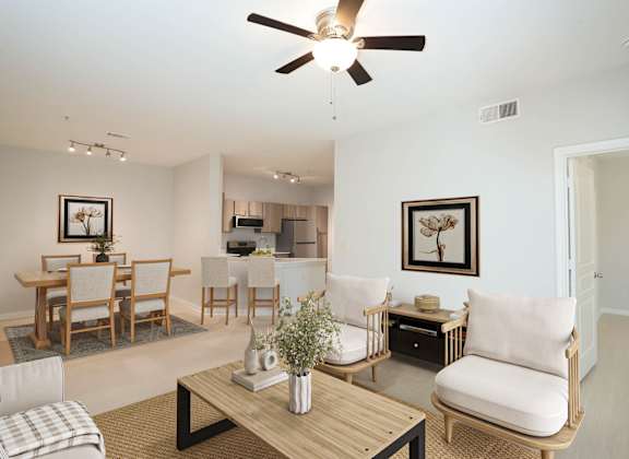 A living room with a ceiling fan and a dining table with chairs.