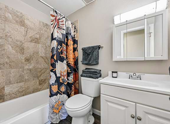 A bathroom with a toilet, sink, and shower.