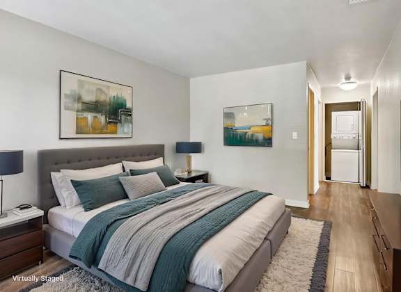 A bedroom with a large bed and a painting on the wall.
