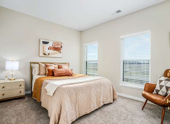 a bedroom with a bed and two windows