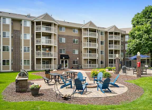 an outdoor patio with tables and chairs in front of an apartment building at Cityscape, St Louis Park, Minnesota
