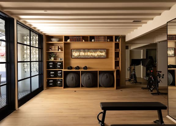 A gym with a wooden floor and a sign that says  at The PARKER on E Mulberry Apartments, San Antonio, Texas