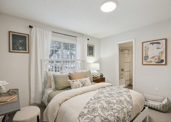 A bedroom with a large bed and a painting on the wall at St. Andrews Reserve Apartments in Wilmington, NC