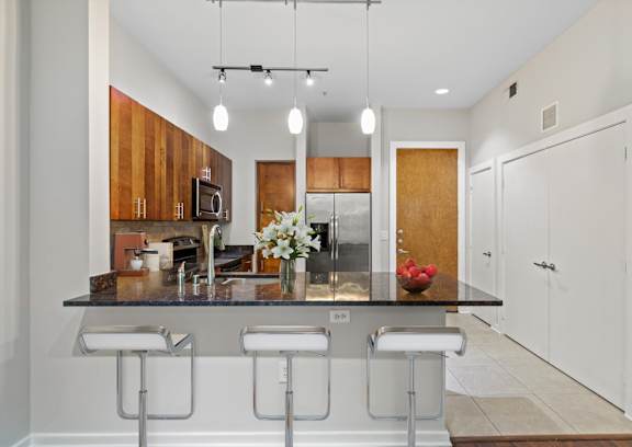 a kitchen with a large island with four stools in front of it