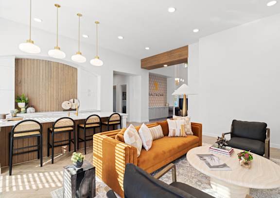 a living room with an orange couch and a kitchen with a table and chairs