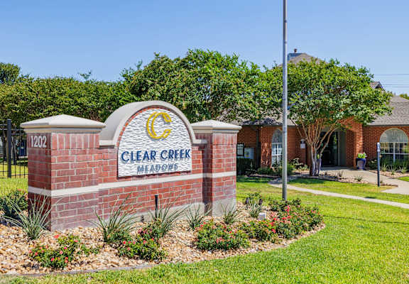 a brick sign with the words clear creek memories in front of a brick building