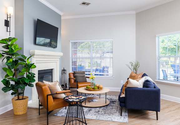 a living room with gray walls and a fireplace with a tv above it at Clear Creek Meadows Apartments, Copperas Cove, TX, 76522